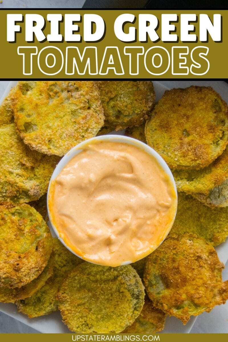 Plate of air fryer fried green tomatoes arranged around a bowl of creamy dipping sauce, viewed from above.