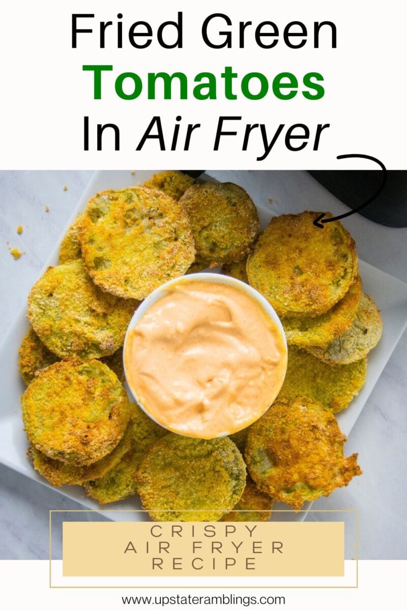 A plate of air fryer fried green tomatoes arranged around a bowl of creamy dipping sauce, all on a white square plate.