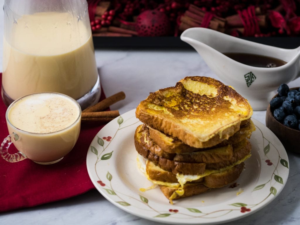 Stack of French toast on a plate next to homemade eggnog