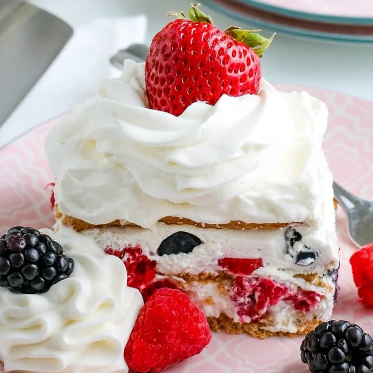 summer berry icebox cake with extra whipped cream and berries