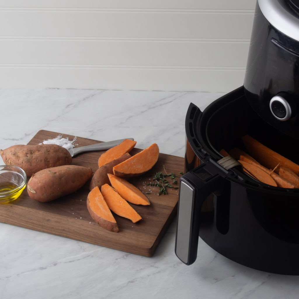 air fryer with sweet potatoes next to it