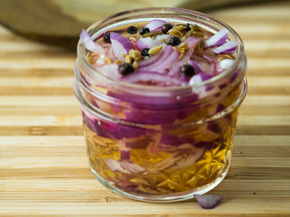 jar of pickled onions on a cutting board