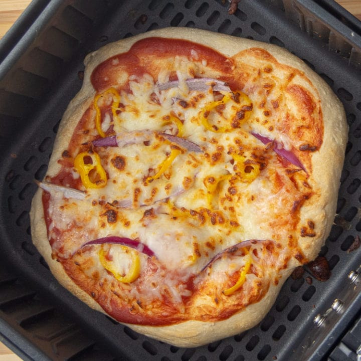 pizza in air fryer basket after cooking