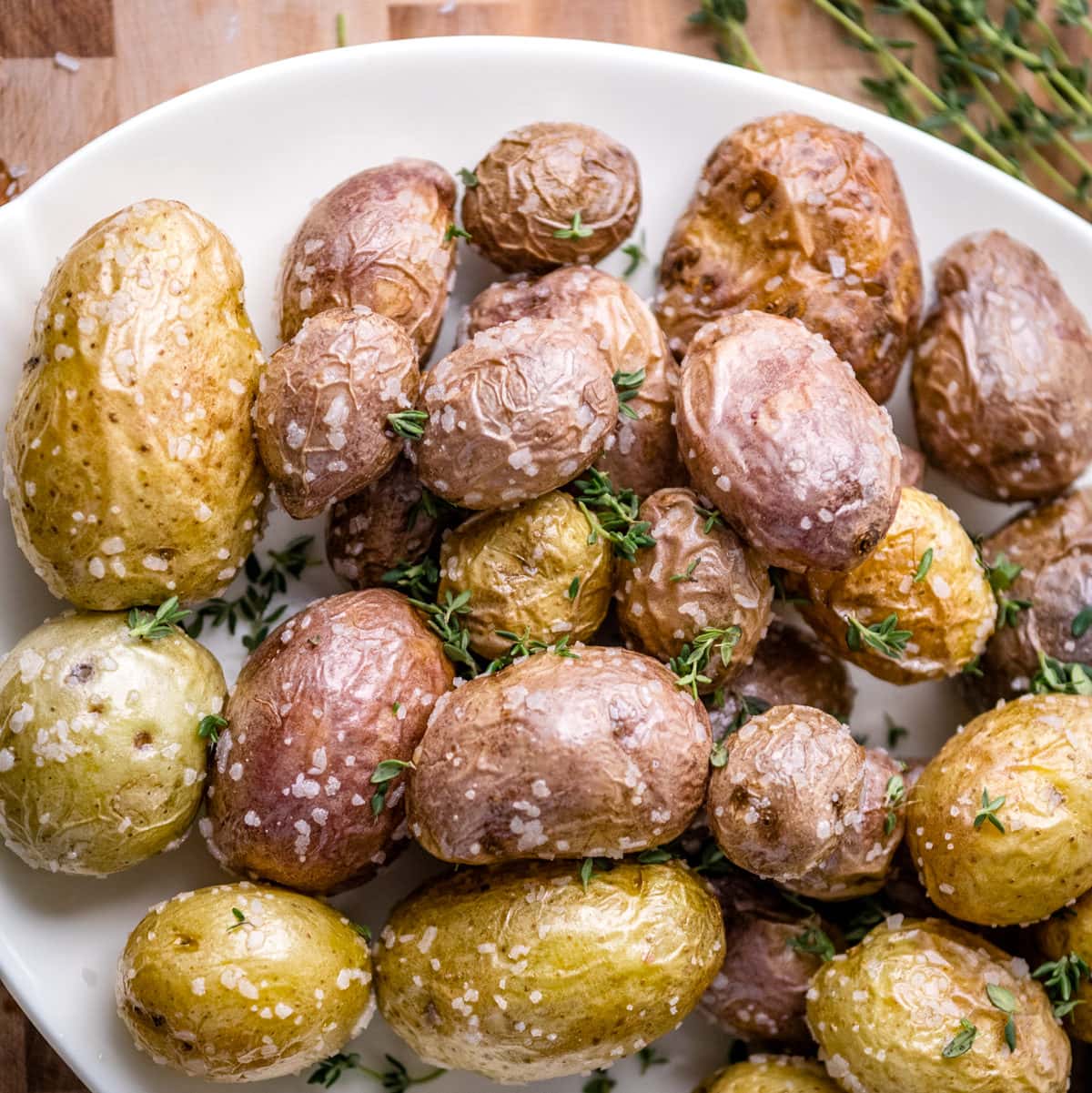 Top view of a plate of yellow and purple baby potatoes with salt.
