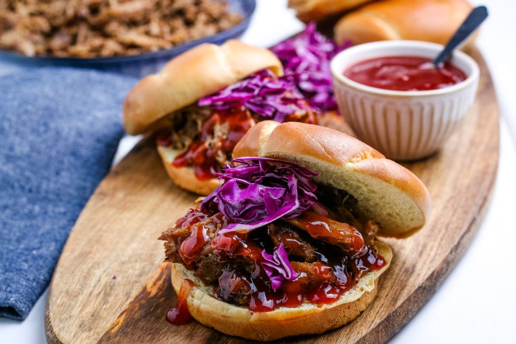 Instant Pot Pulled Pork sandwiches on a cutting board.
