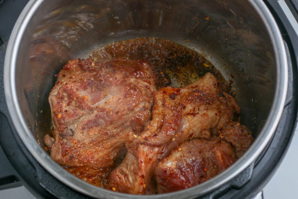 A meat-filled instant pot on a stove.