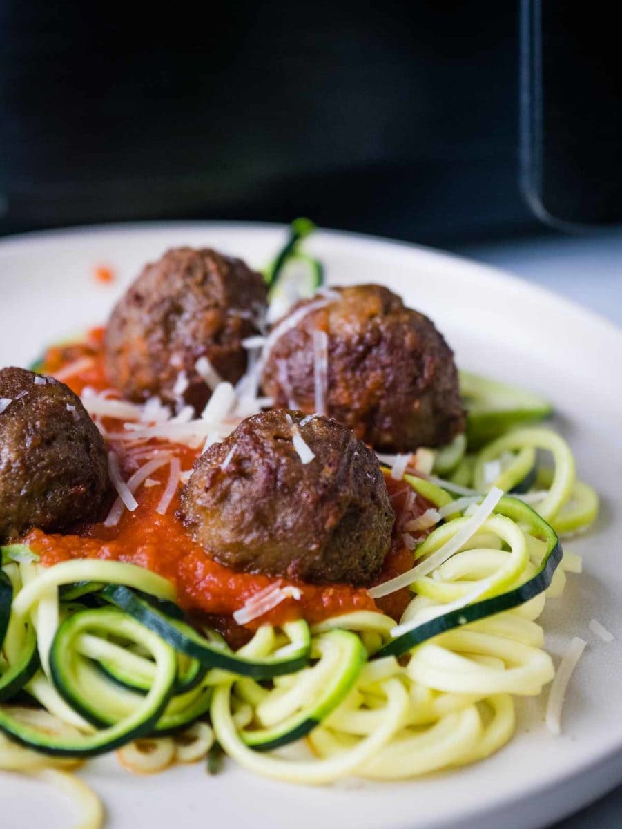 meatballs with zoodles on a plate in front of air fryer