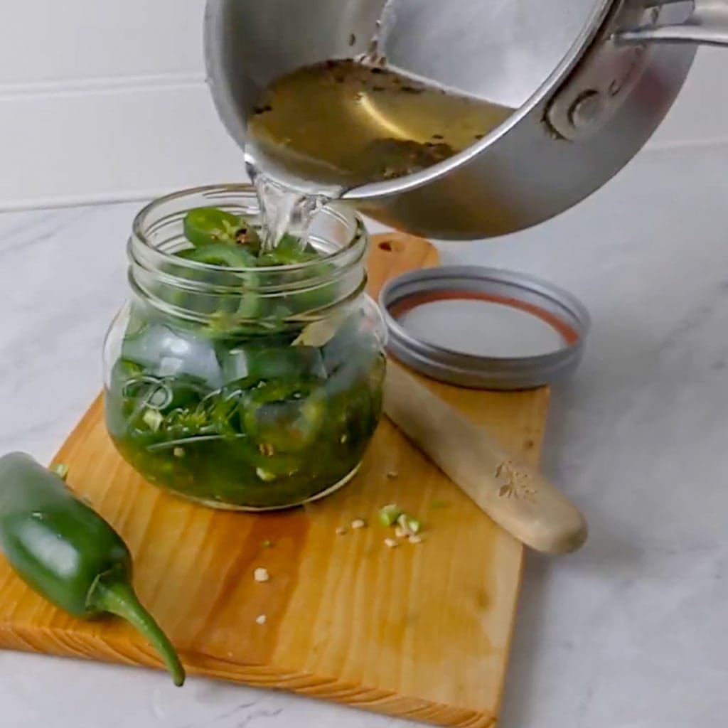 adding brine to the pickle jar