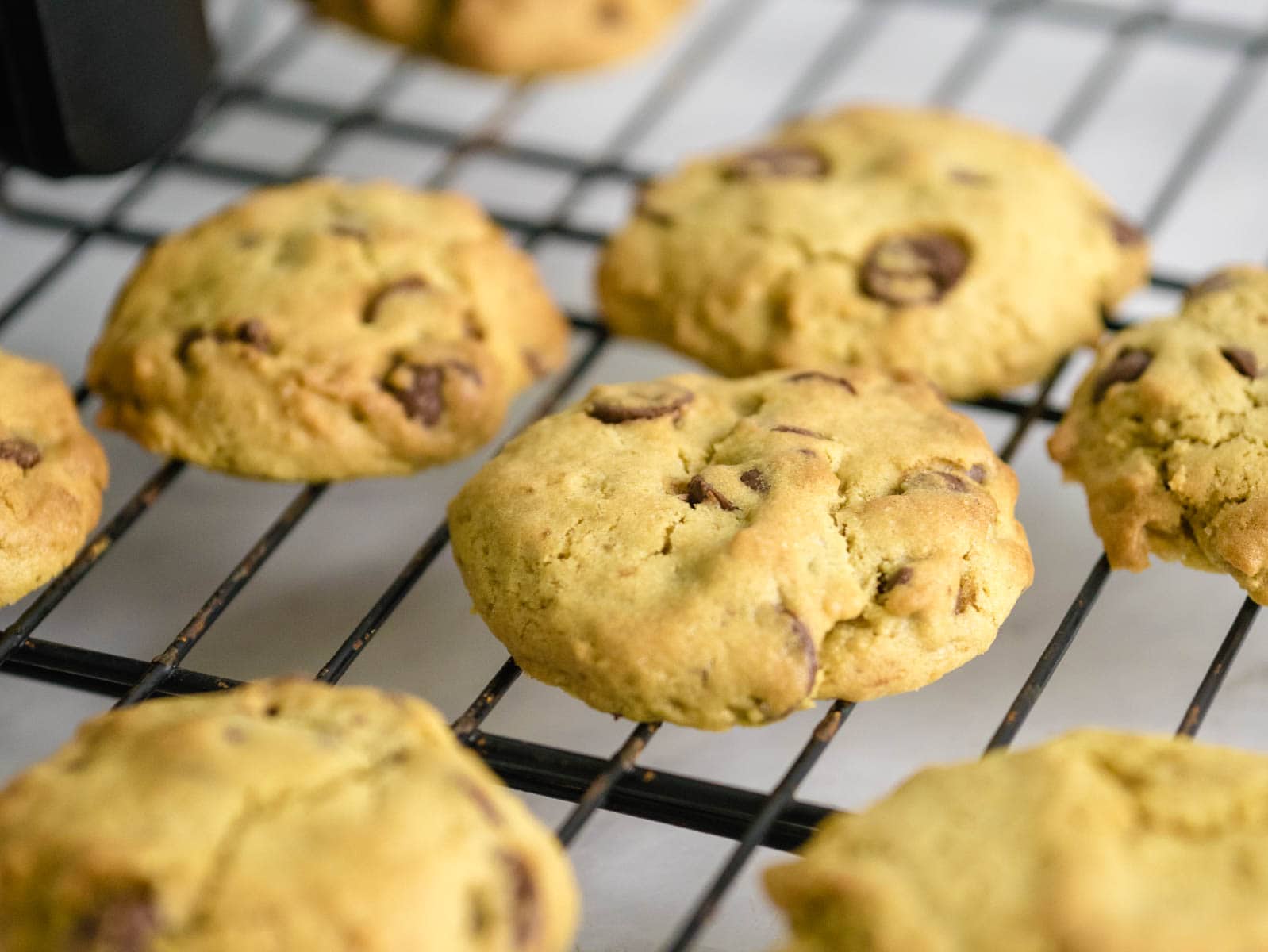 Air Fryer Chocolate Chip Cookies with milk in the background.