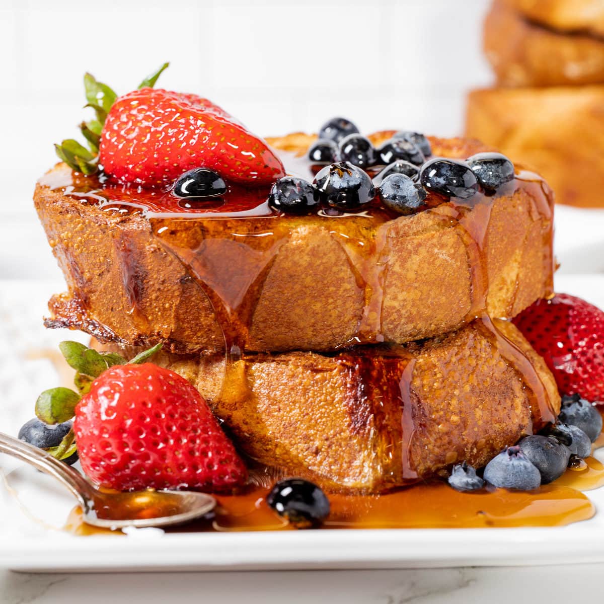 side view of french toast on a plate with berries