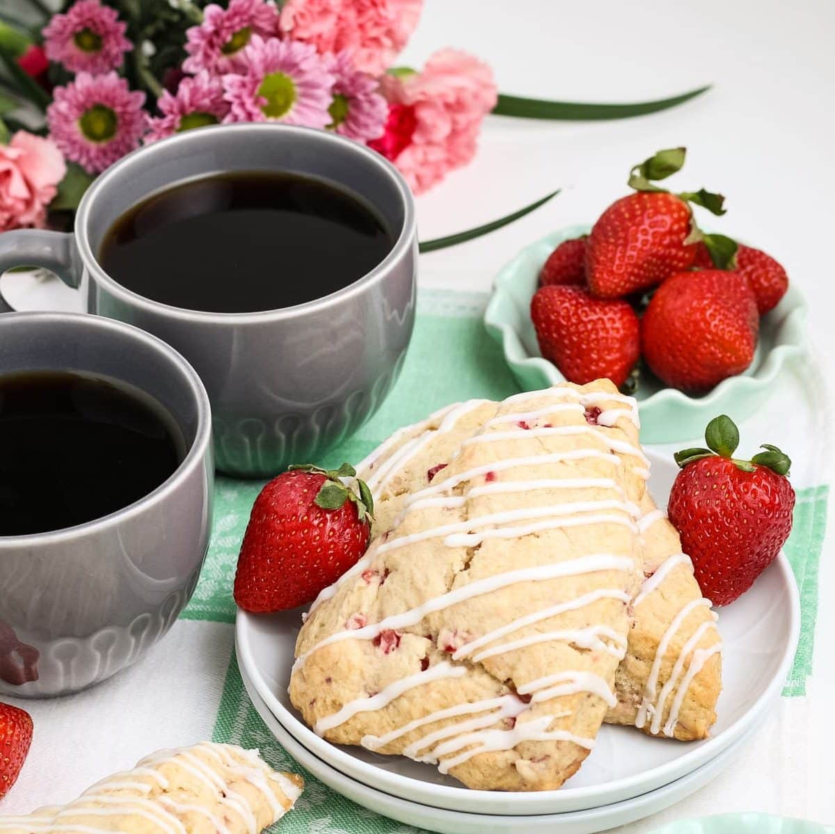 Strawberry scones on a plate with coffee on the side.