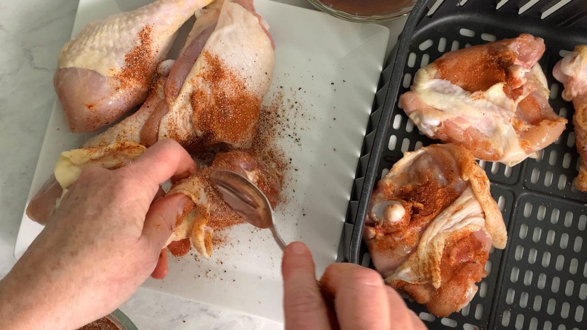 adding spices to the chicken
