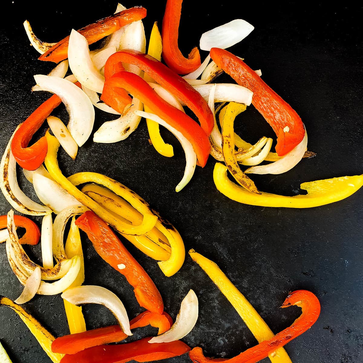 peppers and onions on a griddle