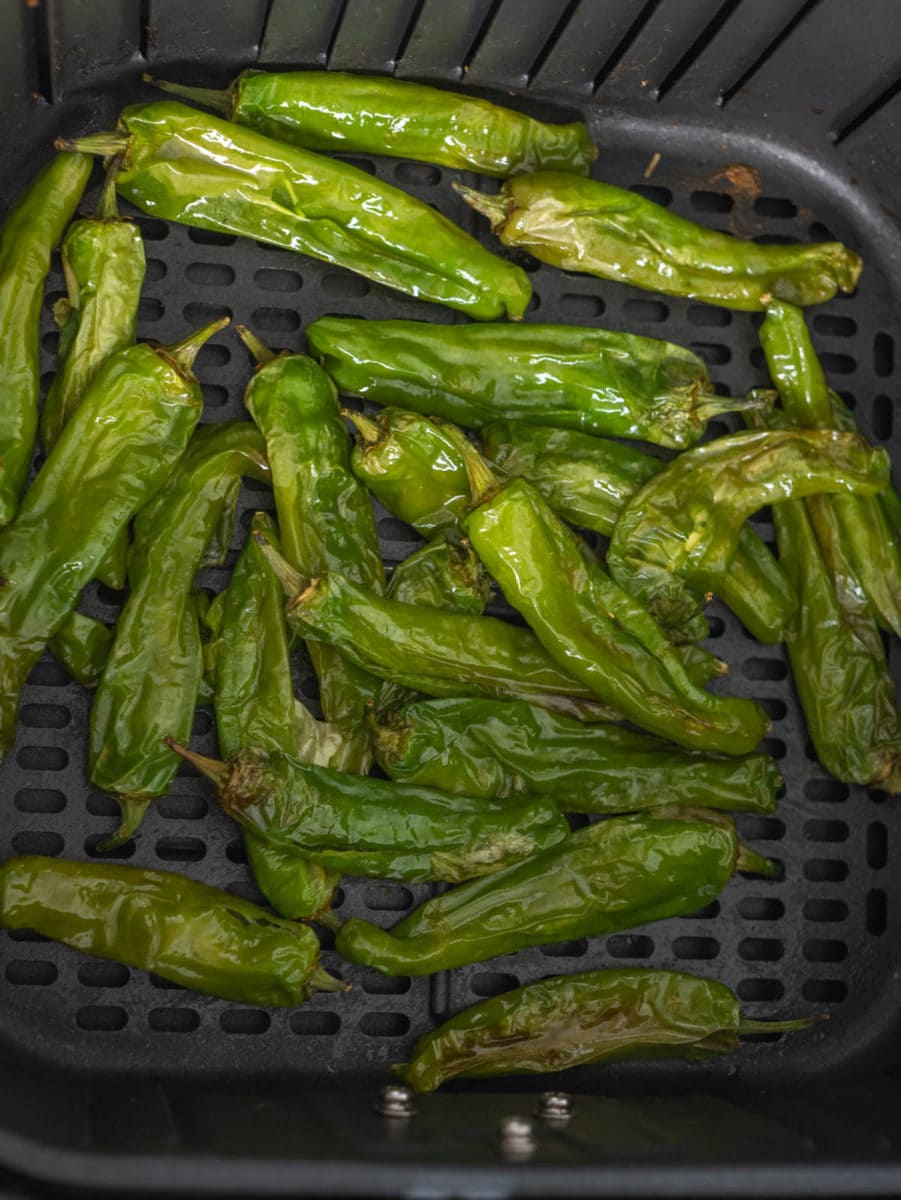 closeup of shishito peppers in the air fryer basket
