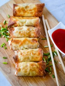 sweet and sour egg rolls on a cutting board