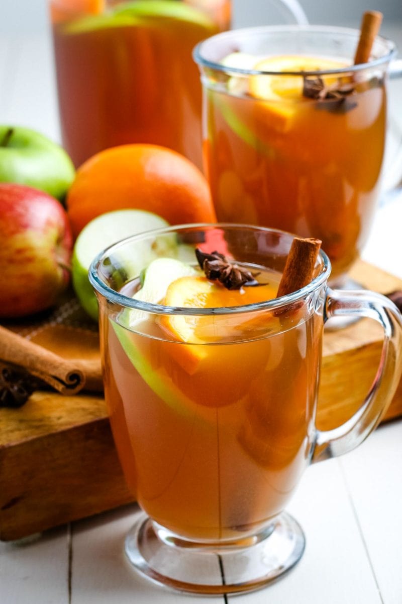 apple cider in glasses with sliced apples and spices