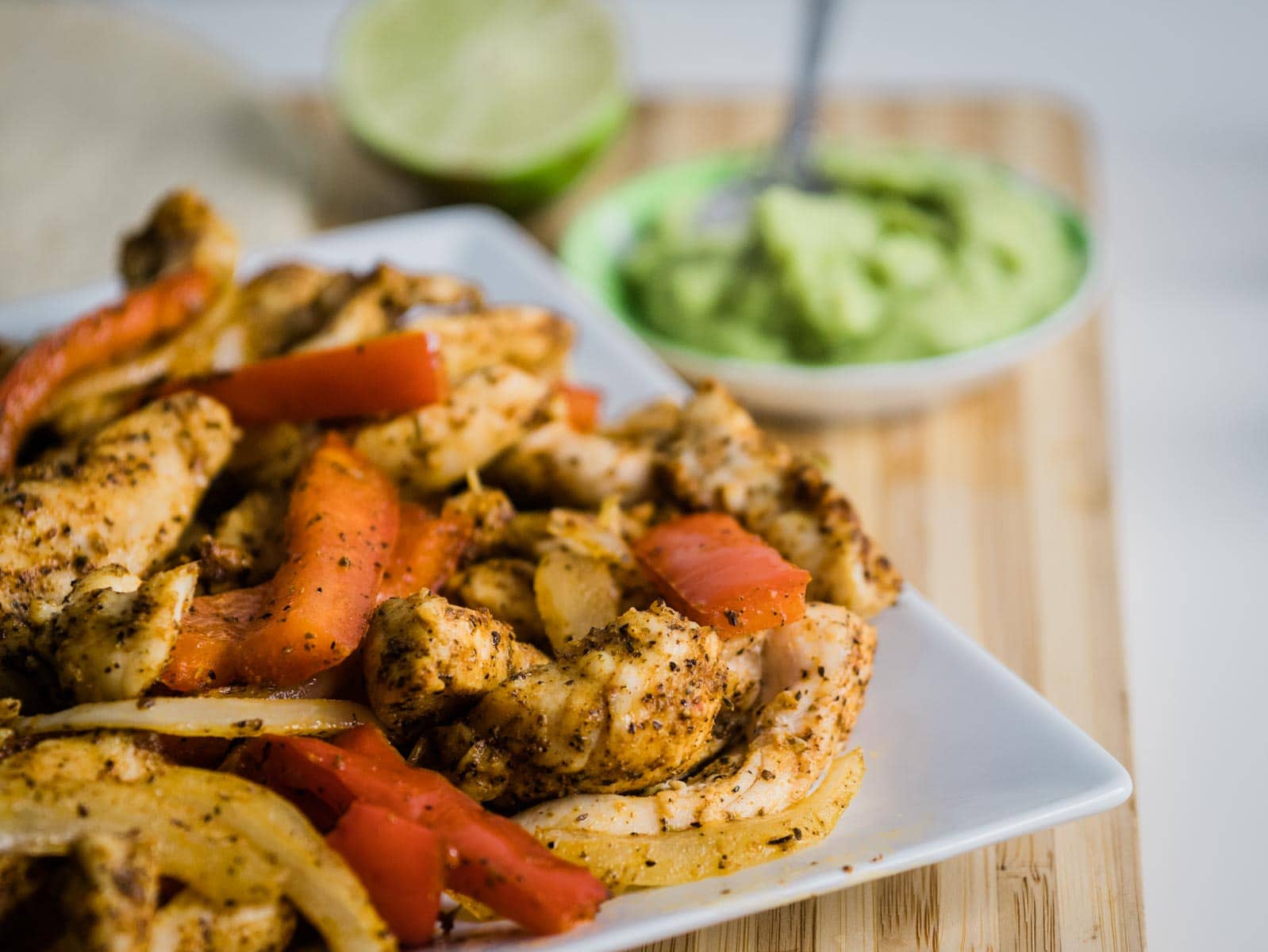 Plate of chicken fajitas with chicken, red bell peppers and onion.