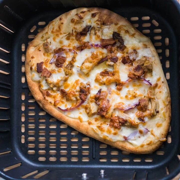naan pizza in air fryer basket after cooking