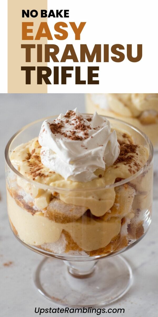 A glass serving dish with layers of cream, ladyfingers, and cocoa powder, topped with whipped cream. Text: "No Bake Easy Tiramisu Trifle.