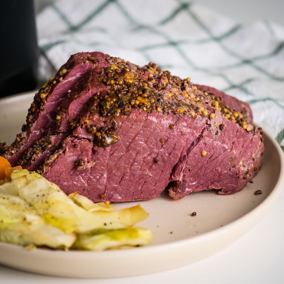 Air fryer corned beef on a plate with veggies.
