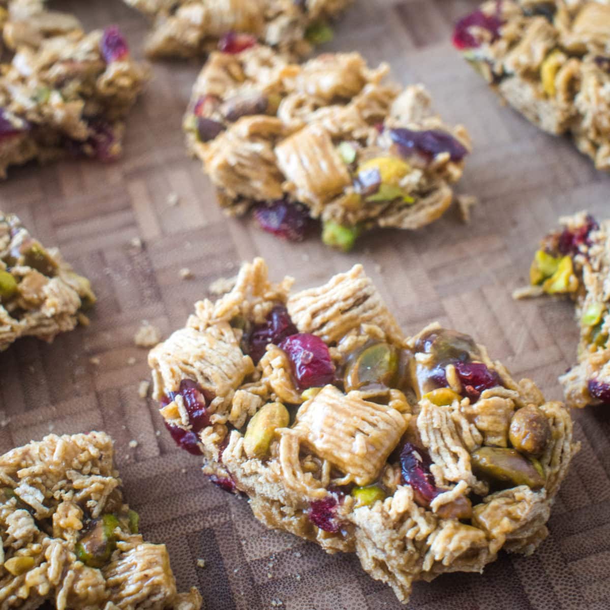 cereal bars with cranberry and pistachios on a cutting board.