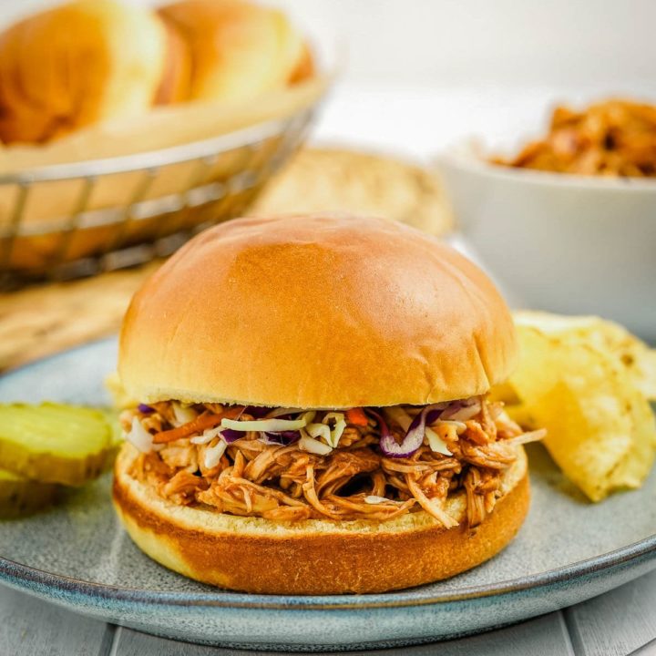 pulled chicken on a plate with coleslaw and pickles