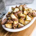 roast potatoes on a dish with a fork in the background
