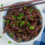 top view of Mongolian beef in a bowl with chopsticks