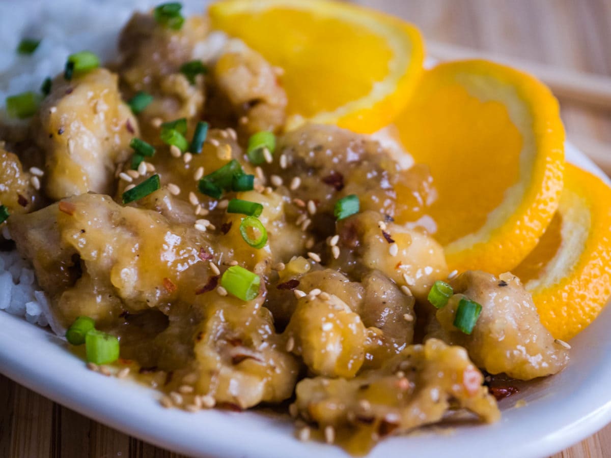 closeup of orange chicken with sesame seeds and green onions