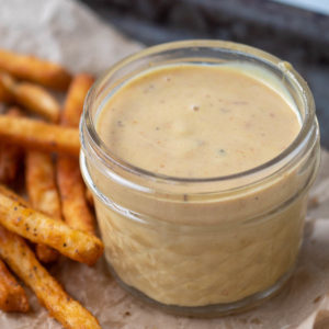 Chick-fil-A sauce in a jar next to French fries