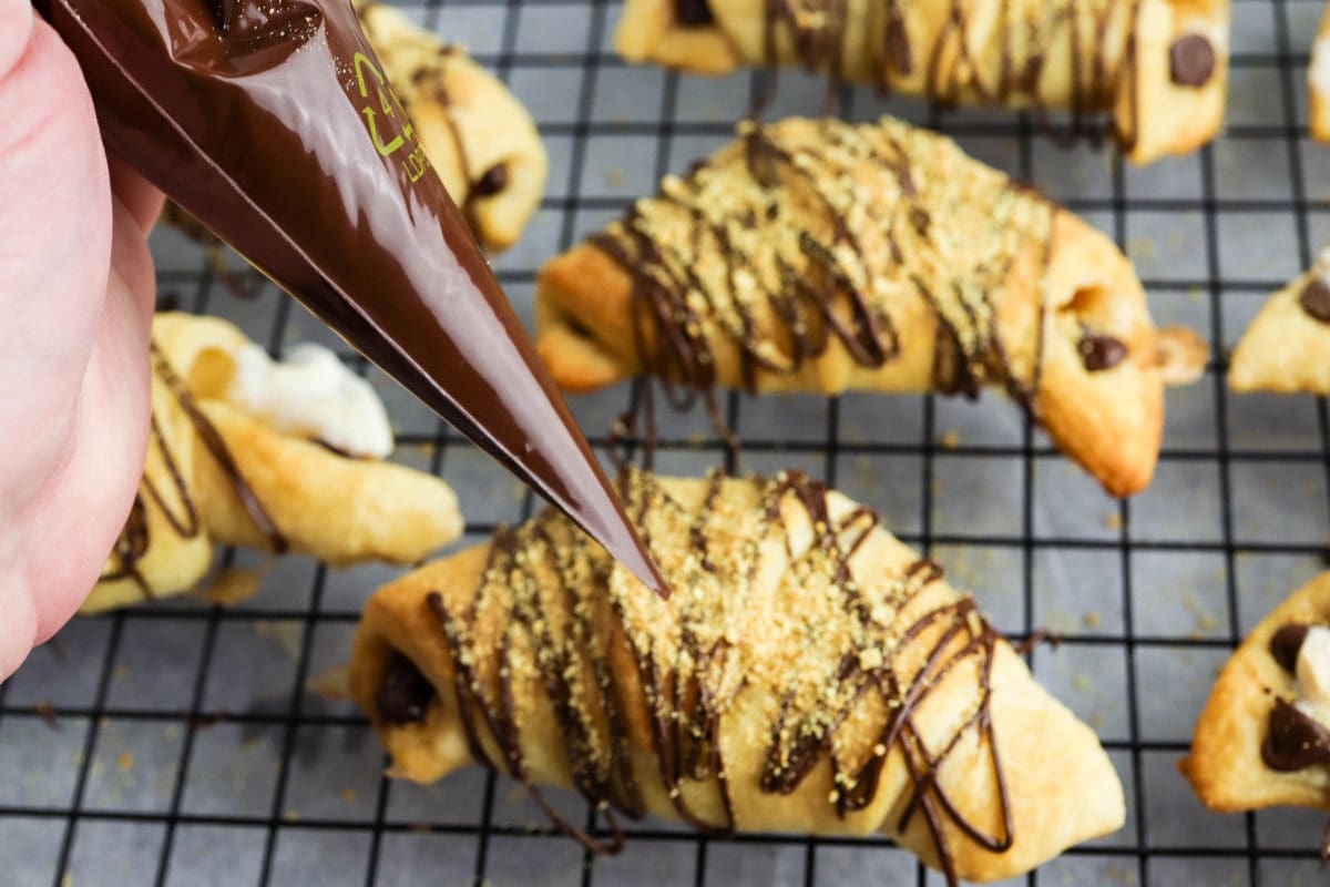 adding chocolate drizzle to the crescent rolls