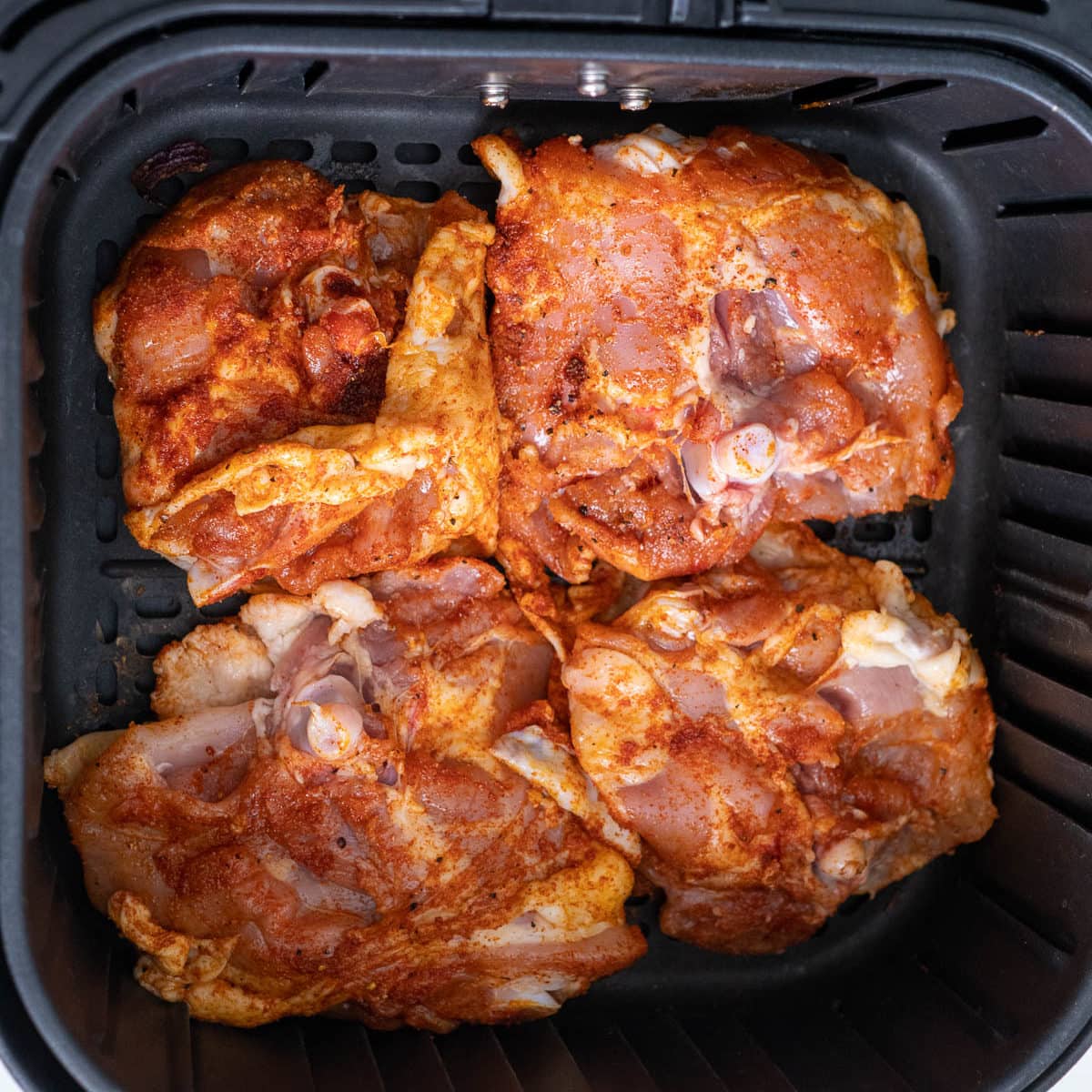thighs in air fryer basket with the skin side down