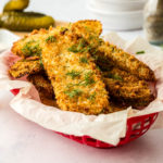 air fryer fried pickles in a basket with dill