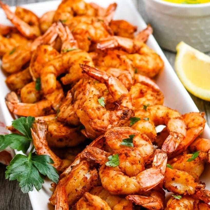 shrimp on a platter in front of the air fryer