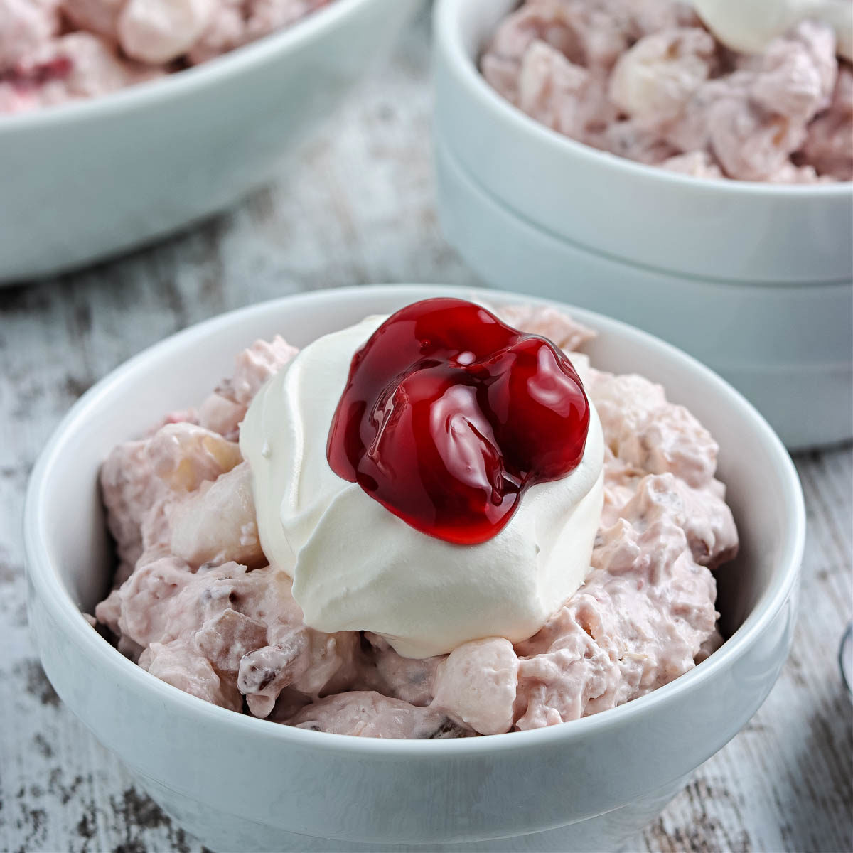 cherry salad topped with whipped cream and cherries