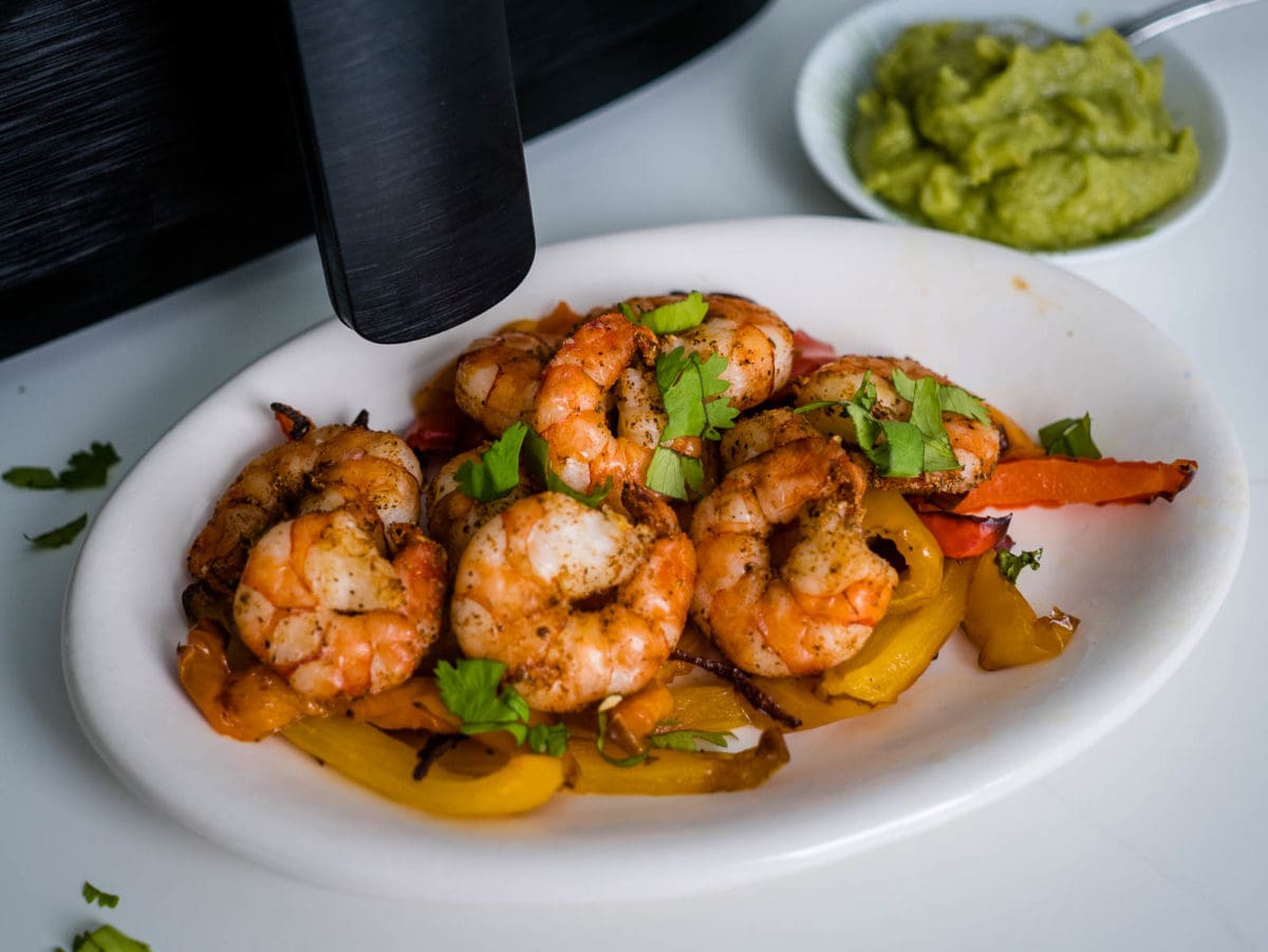 shrimp fajitas on a platter in front of air fryer