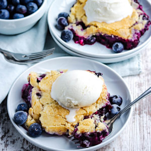 closeup of old fashioned blueberry cobbler with vanilla ice cream