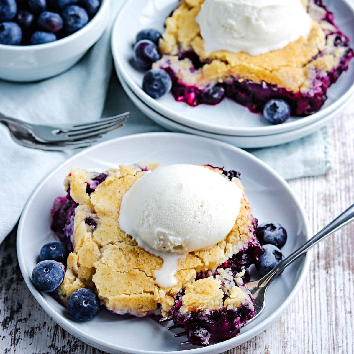 closeup of old fashioned blueberry cobbler with vanilla ice cream