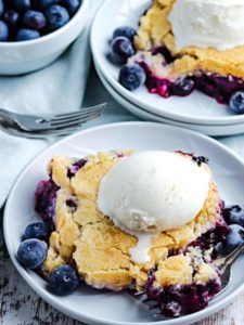 closeup of old fashioned blueberry cobbler with vanilla ice cream