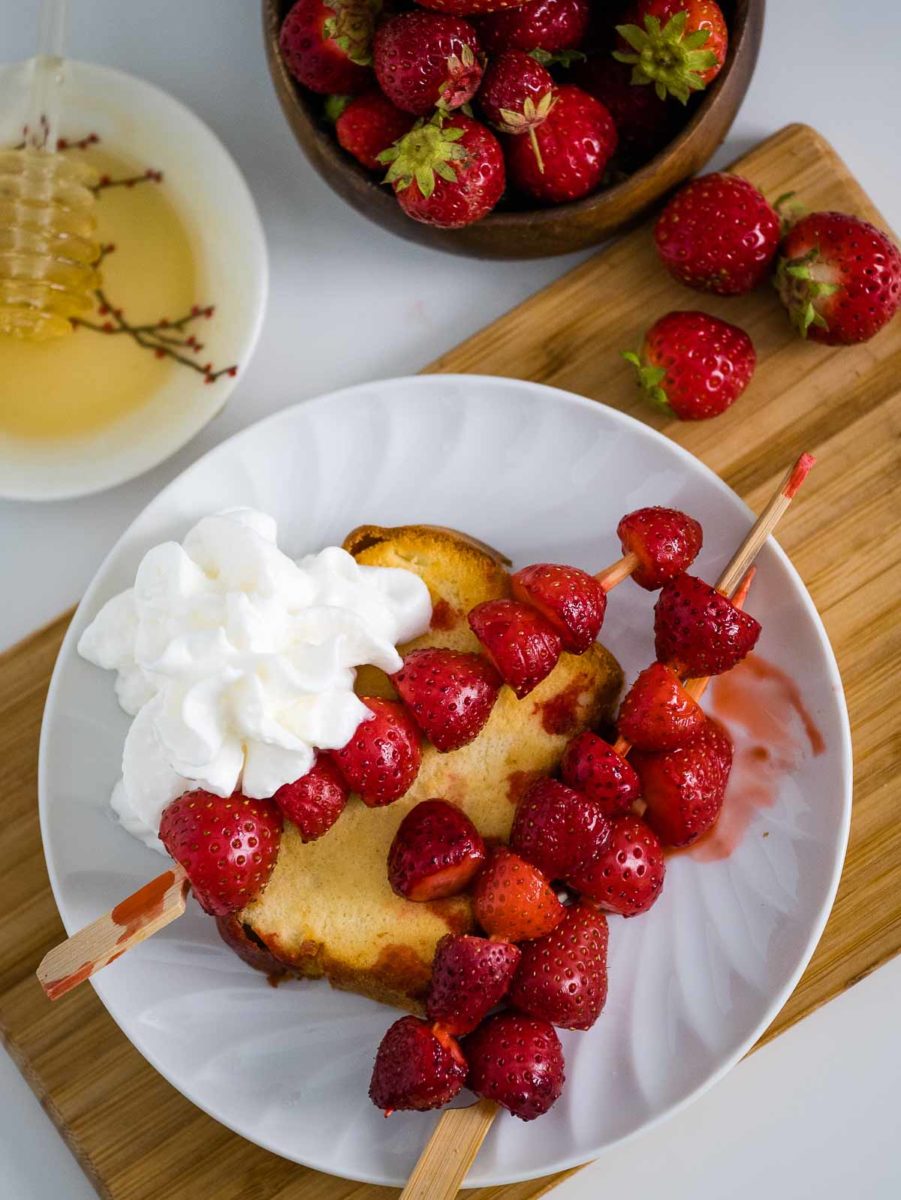 top view of air fryer strawberry shortcake on a plate with whipped cream