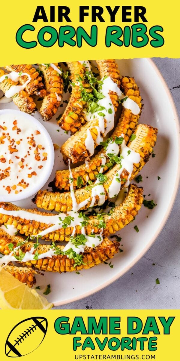 A plate of crispy air fryer corn ribs drizzled with a white sauce and garnished with chopped herbs. The text reads "Air Fryer Corn Ribs - Game Day Favorite." A lemon wedge and football graphic are also visible.