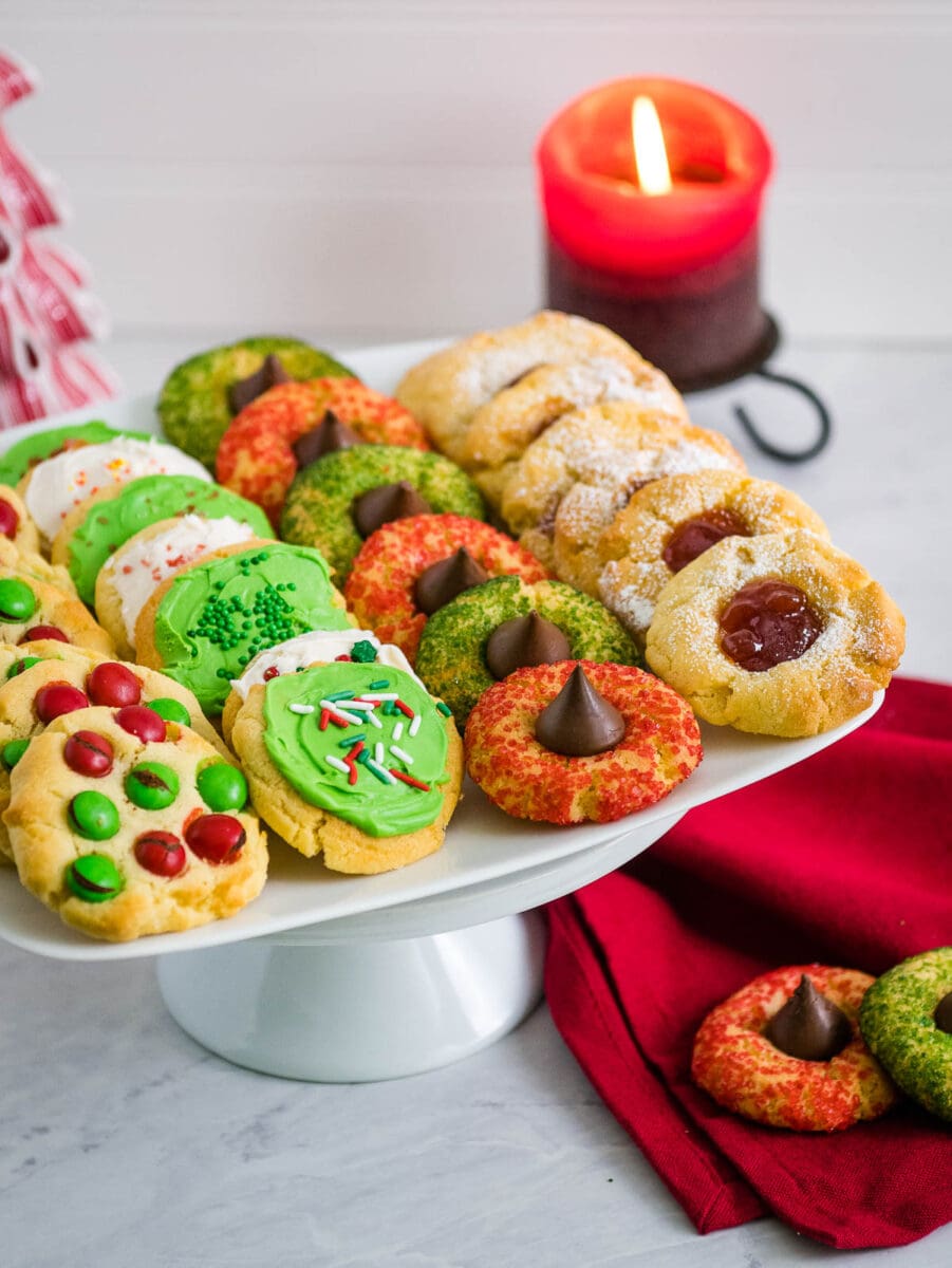 tray of christmas cookies with a candle in the background