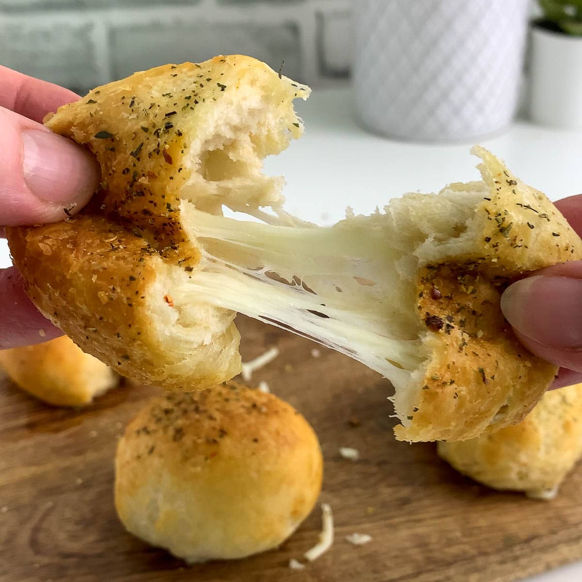 Pulling apart a garlic cheese ball filled with stringy mozzarella cheese.