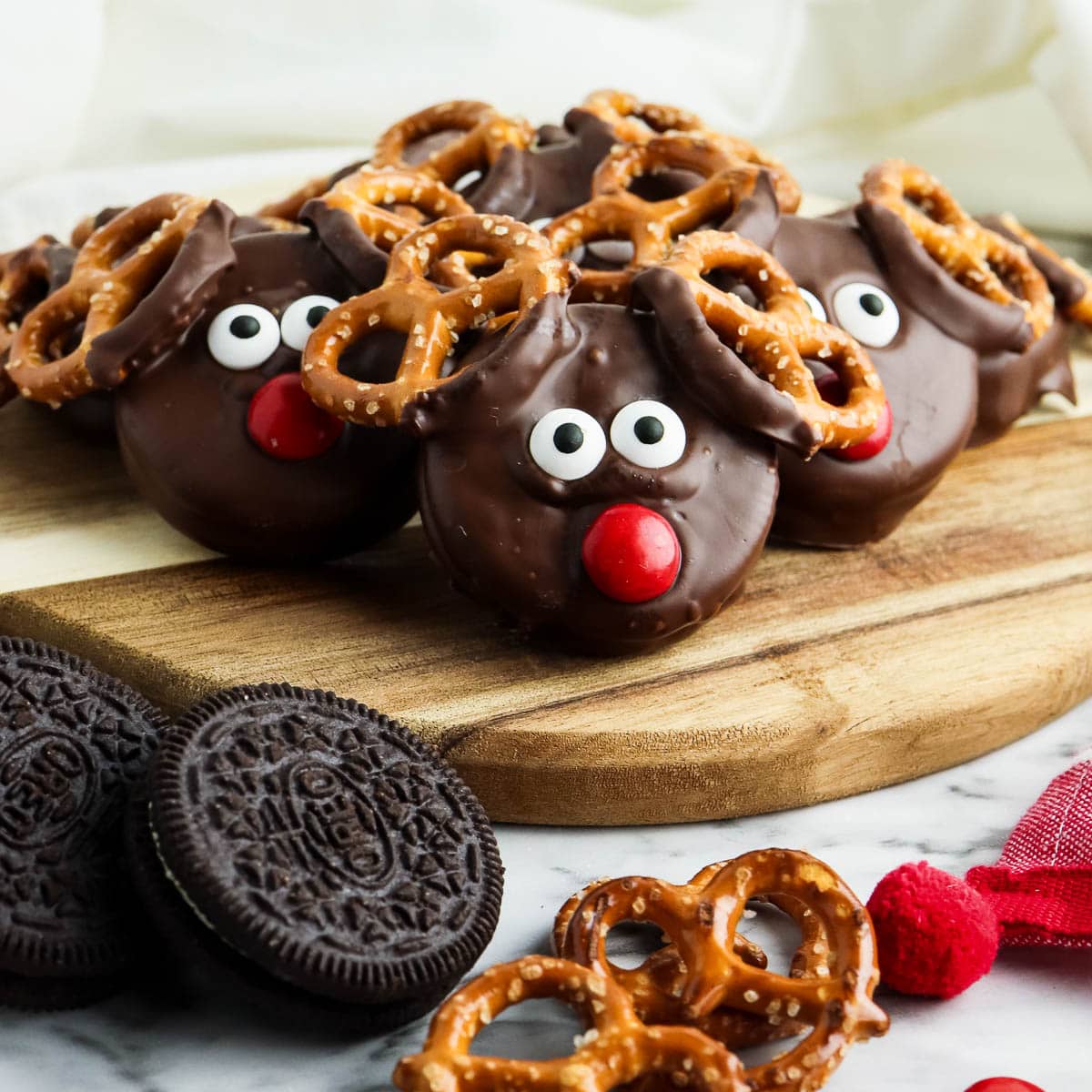Chocolate reindeer cookies on a cutting board.