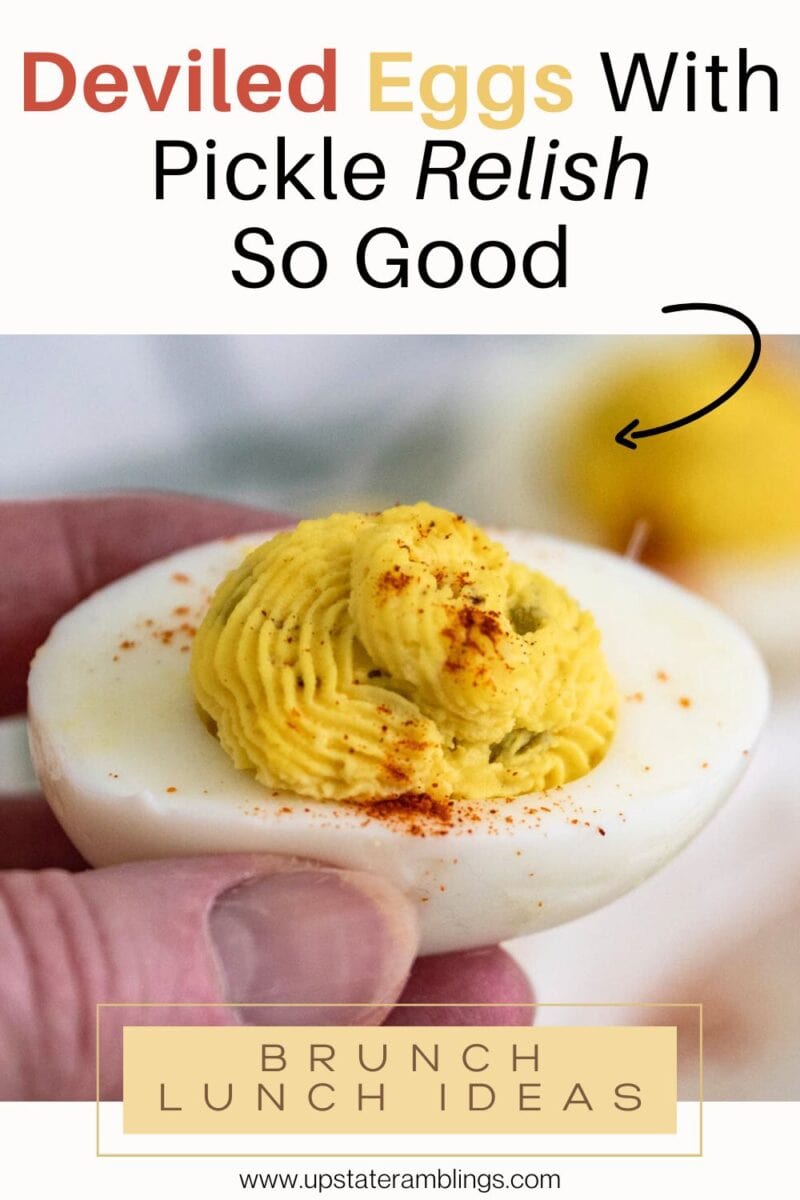 A hand holds a deviled egg with pickle relish and paprika, another deviled egg in the background. Text reads: "Deviled Eggs With Pickle Relish So Good" and "Brunch Lunch Ideas.