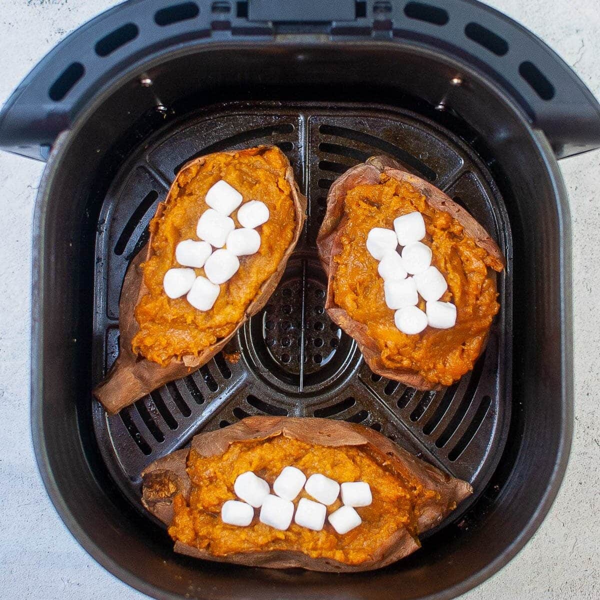 topping the sweet potatoes with marshmallows