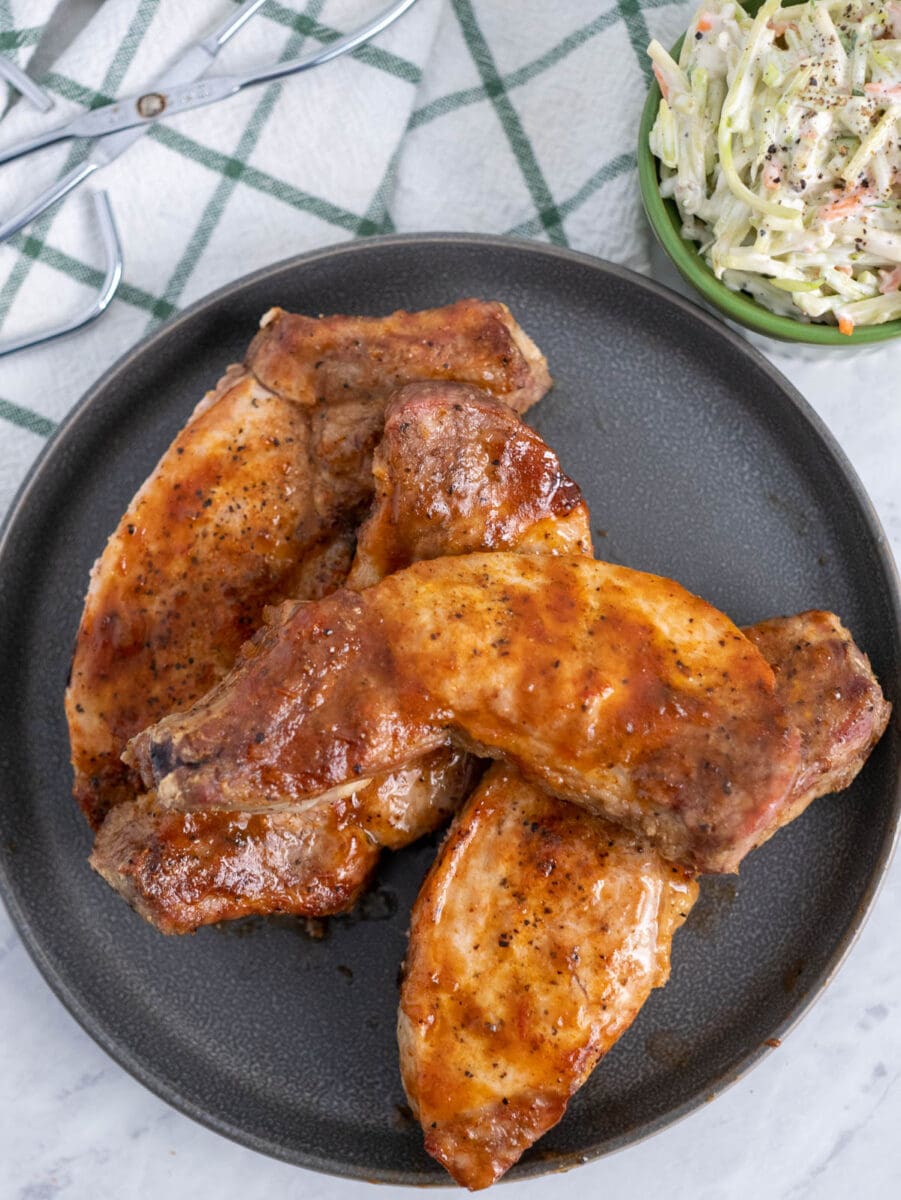 air fryer country style pork ribs on a gray plate with coleslaw.