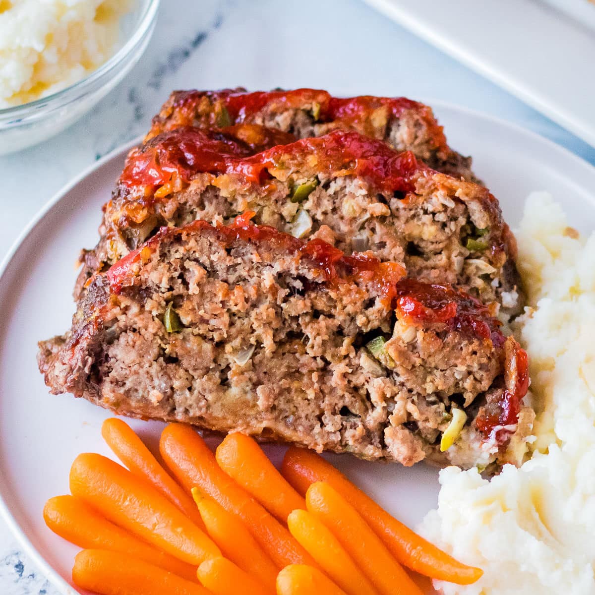 top view of cracker barrel meatloaf on a plate with carrots.