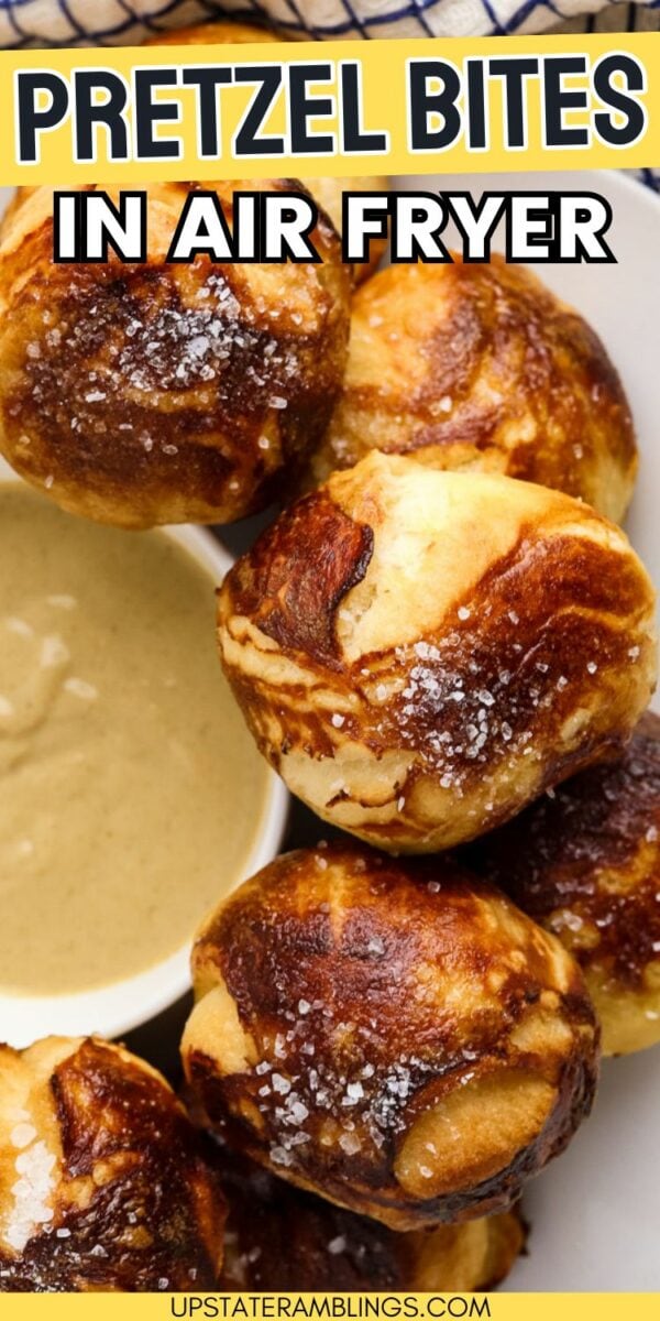 Close-up of golden-brown air fryer pretzel bites with coarse salt, served with a dipping sauce, and the text "PRETZEL BITES IN AIR FRYER" displayed at the top.