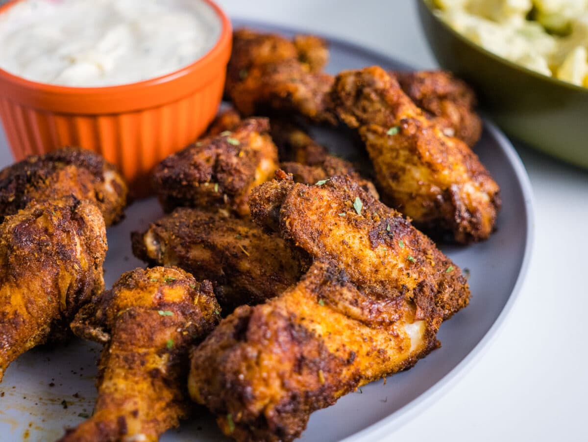 plate with Cajun chicken wings with ranch dip.